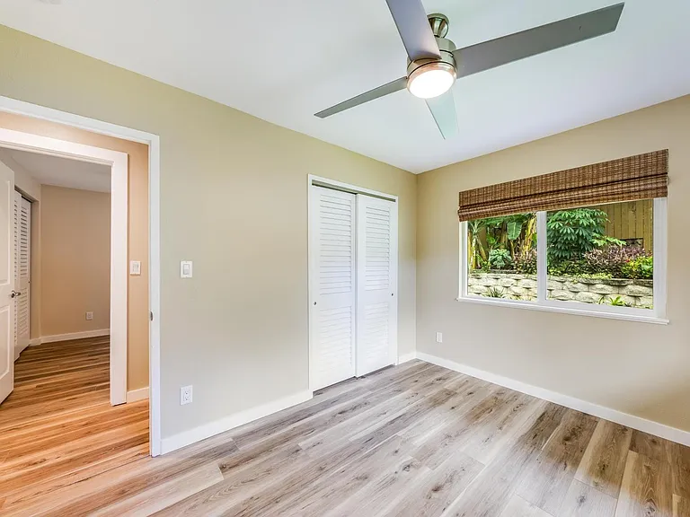 Spacious second-floor bedroom with peaceful greenery views.