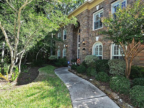 Another view of front of the home with extensive landscaping.