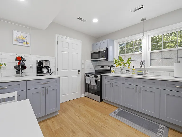 Updated kitchen with ample counter space, stainless appliances, and a large window over the sink for easy meal prep.