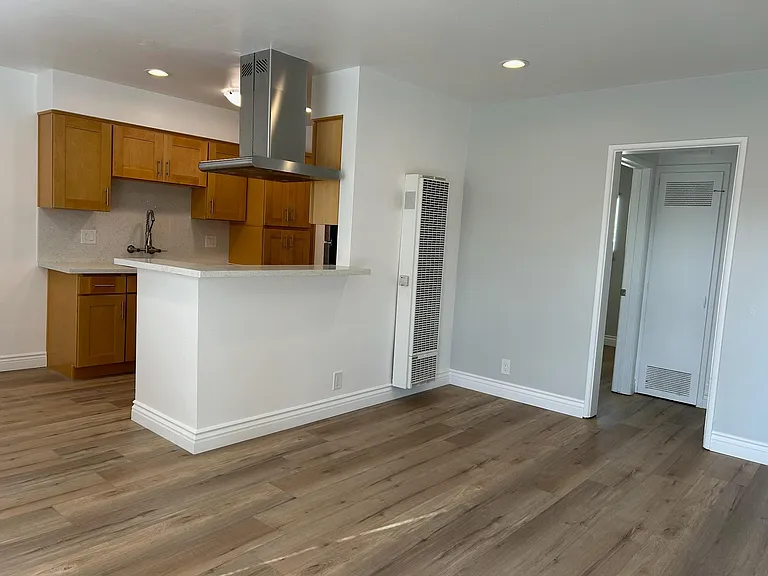 Living room with brand new laminate floors, wood molding, speciality paint, designer kitchen