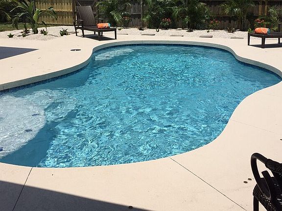 Lanai pool area with lush palm trees, tropical setting in back plenty of space for entertaining or grilling. Heated pool with LED color changing light and privacy from neighbors.