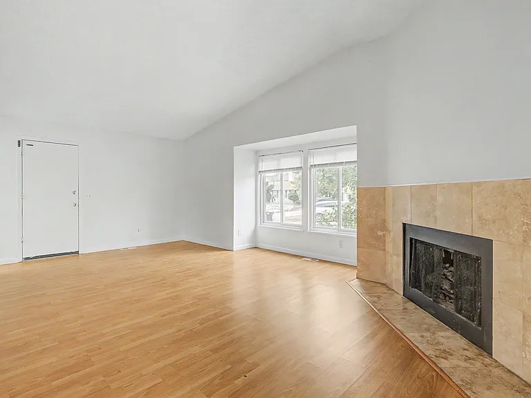 Large living space with wood floor and big windows.