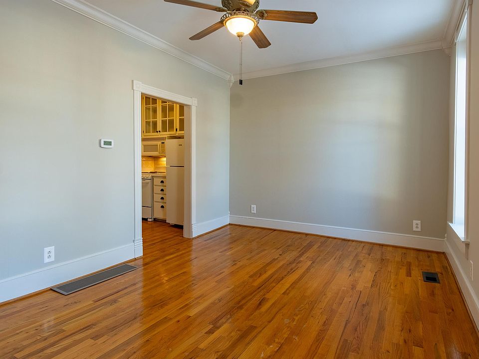 Front living area features high ceilings, oversized windows, hardwood oak flooring and crown molding