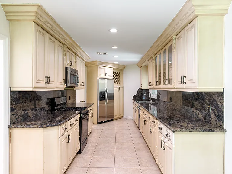 Built-in refrigerator and dark granite counters complete this well-equipped kitchen in a Beverly Hills luxury rental at 1094 Garden Lane, a 90210 lease.