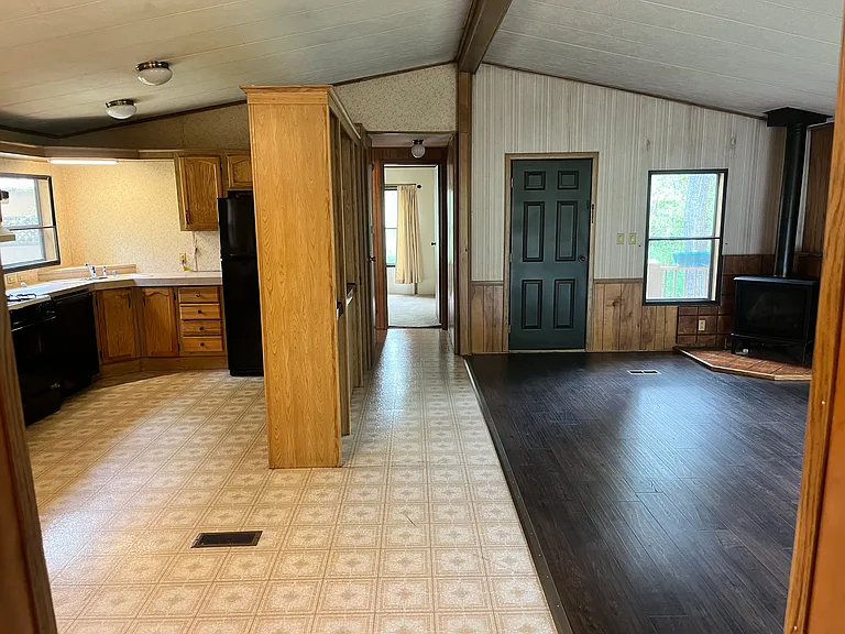 kitchen, living room, and entrance into 1st bedroom (pictured propane stove later replaced with wood-burning stove)