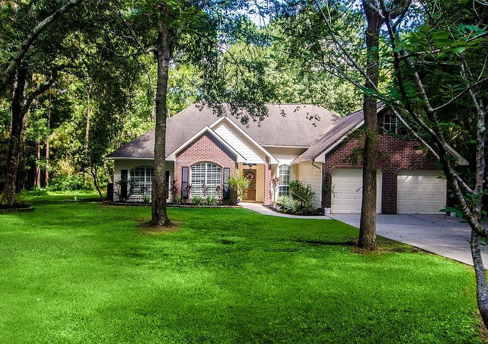 This custom home combines classical architecture with modern, expansive window space to create a bright and airy environment in harmony with its woodland setting.