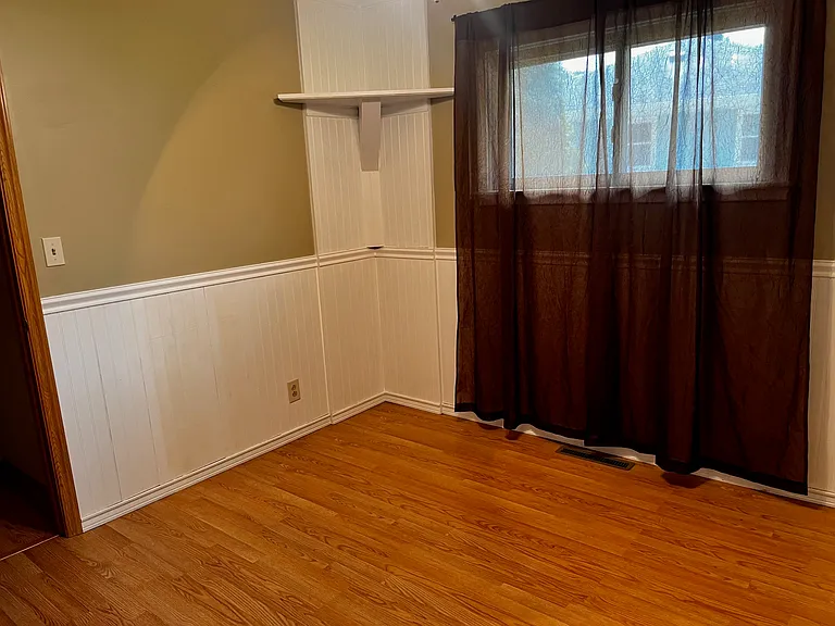back bedroom, with shelfing and wainscoting trim unfurnished