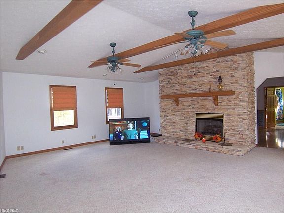Living room also has double ceiling fans and leads to the dining room.