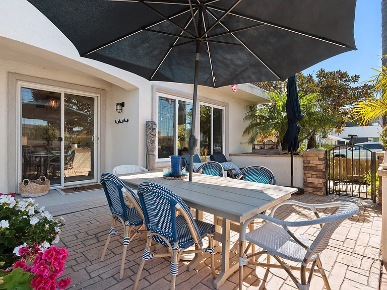 Private outdoor patio with dining table, umbrella seating, and a cozy lounge area