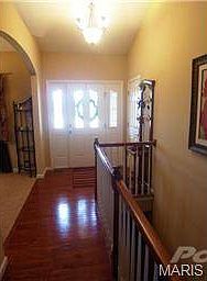 Gleaming wood entry foyer with coat closet.