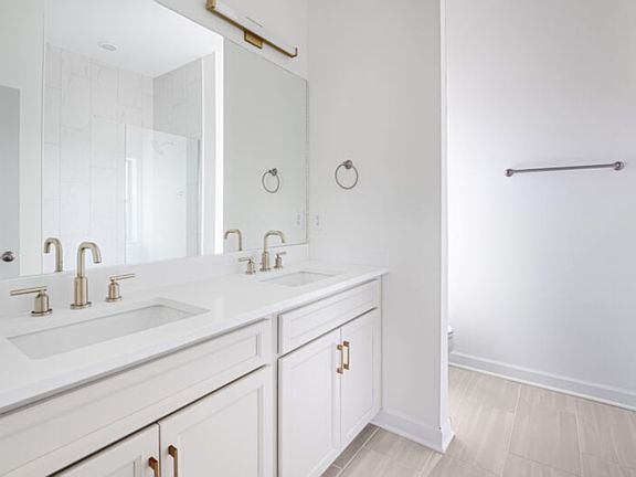 The primary suite offers dual vanity sinks and a walk-in shower.