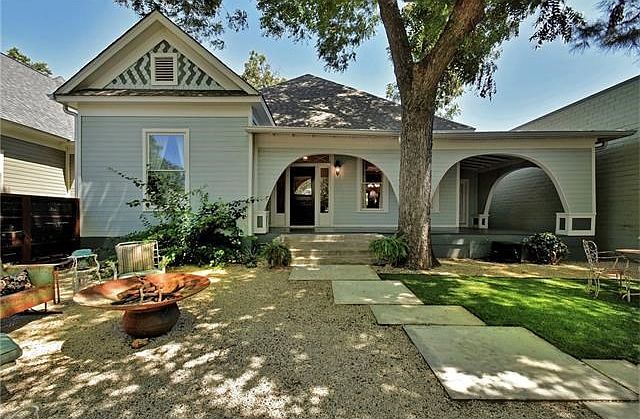 Beautifully landscaped front yard with multiple seating areas and wrap around porch