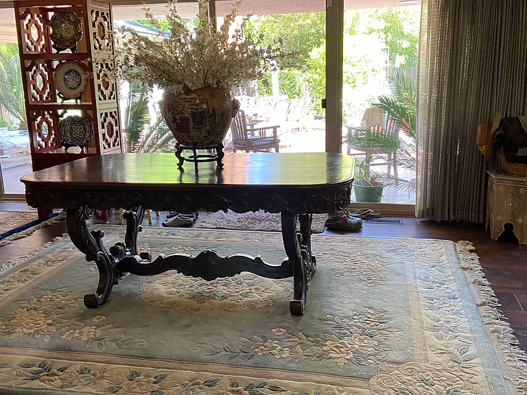 Dining area with a large table, statement light fixture, and sliding glass doors opening to a patio.