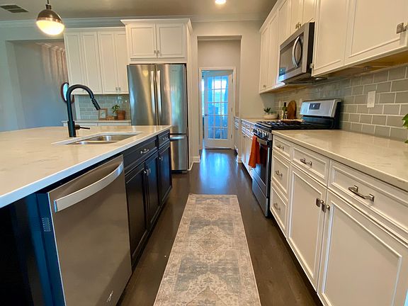 Kitchen with gas stove, stainless appliances and plenty of storage. Corian countertops. French door leads to office/bonus room.