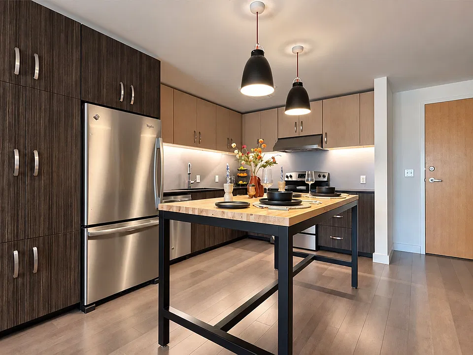 Cook with ease in a modern Farmers Park Apartments kitchen, featuring stainless steel appliances, dark cabinetry, and a spacious island. Schedule a tour today!