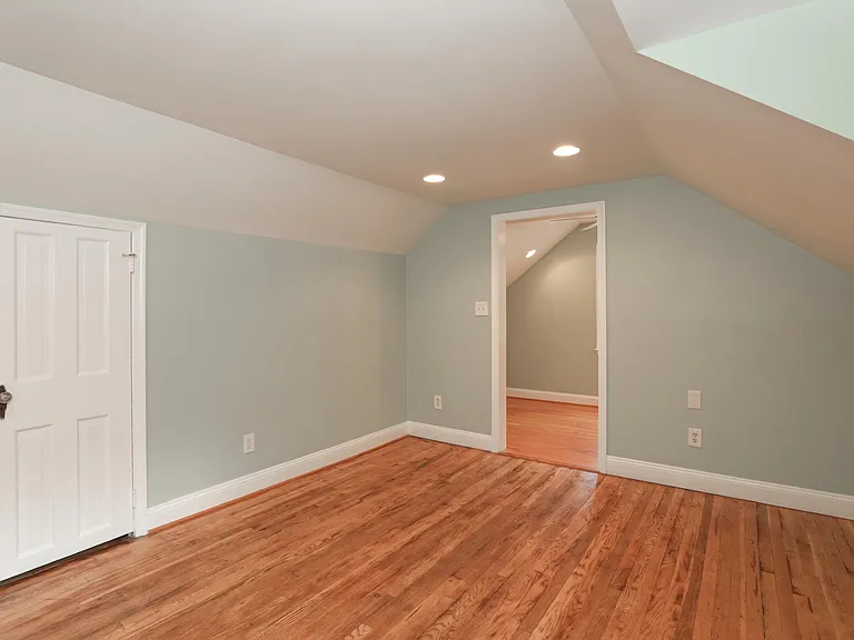 Upper bedroom showing hallway connection and recessed lighting.