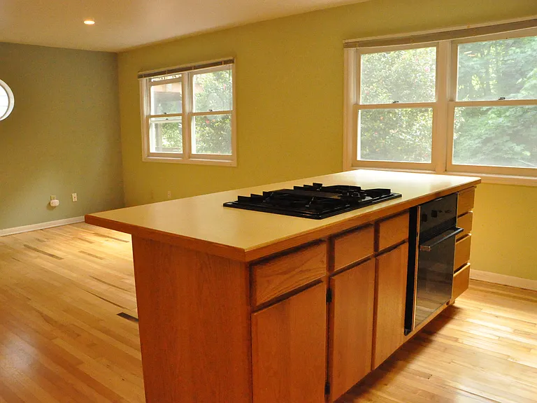 Gas stovetop on kitchen island in great room with high ceilings.