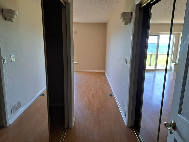 Entrance into primary bedroom. 2 large, mirrored closets on either side of short hallway into room.