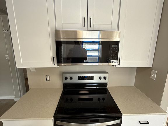 Kitchen; lots of cabinets and cupboards, featuring brand new quartz countertops. Brand new oven range, microwave, fridge, dishwasher, and sink garbage disposal all included