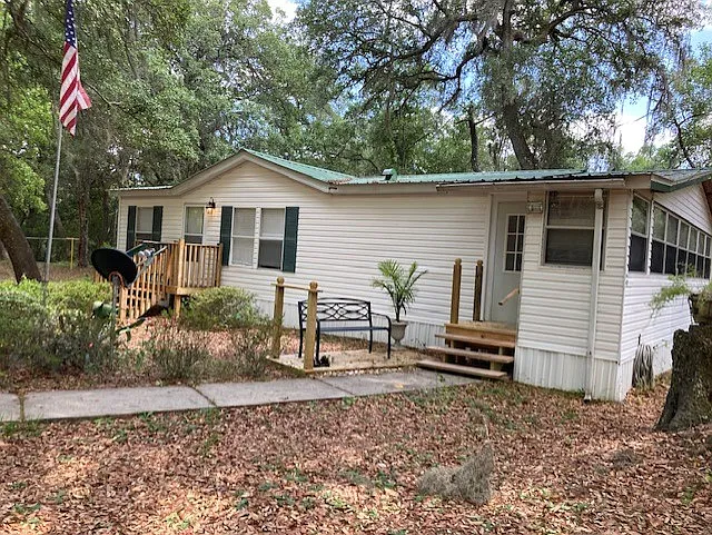 Handrail on both house entrances. Primary door leads to home Living room and secondary entrance leads to Enclosed Sun Room.