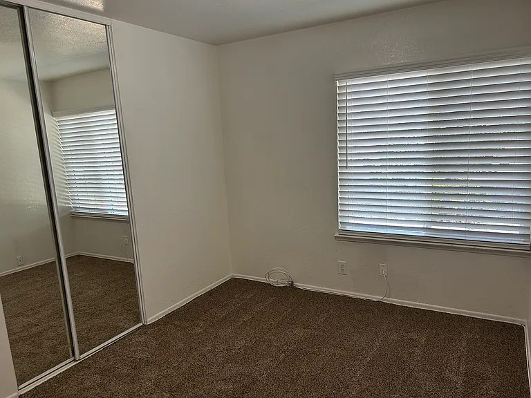 SOUTH WEST 9'X10' BEDROOM WITH 2" CUSTOM BLINDS AND MIRRORED DOORS