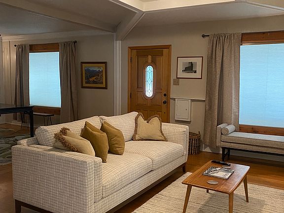 LIVING AREA WITH TV WITH LARGE WINDOW SHOWING SHADE CLOSED IN THIS PIC