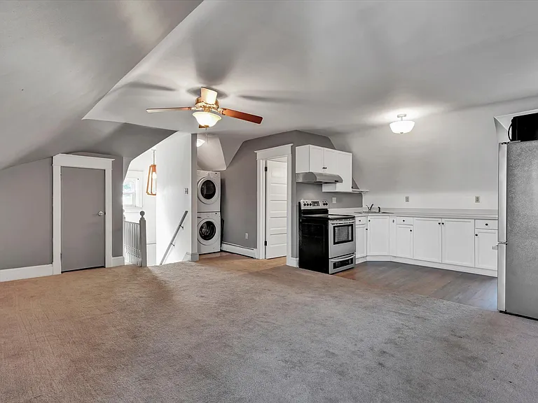 In-Unit Washer/Dryer Unit, stair entrance leading to living room and kitchen with stainless steel appliances.