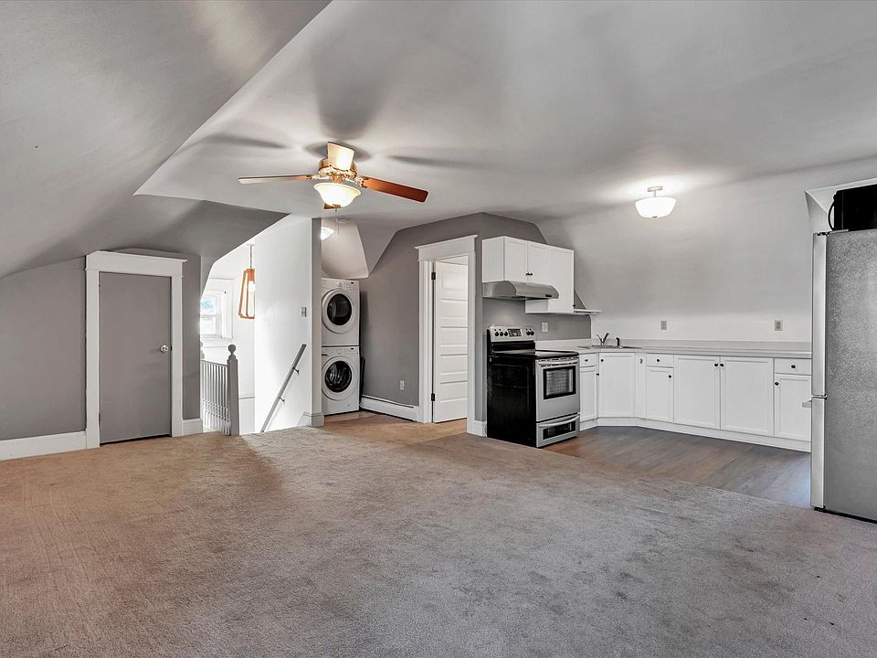 In-Unit Washer/Dryer Unit, stair entrance leading to living room and kitchen with stainless steel appliances.