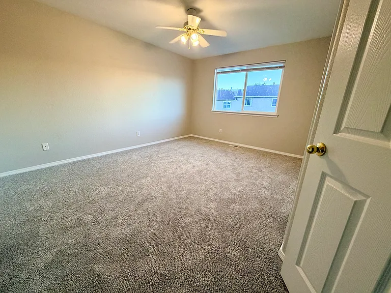 View from entry to comfortable secondary bedroom with double closets, natural light, and direct access to the Jack-and-Jill bathroom. Flexible layout works well as a bedroom, guest room, home office, creative space, or personal retreat.