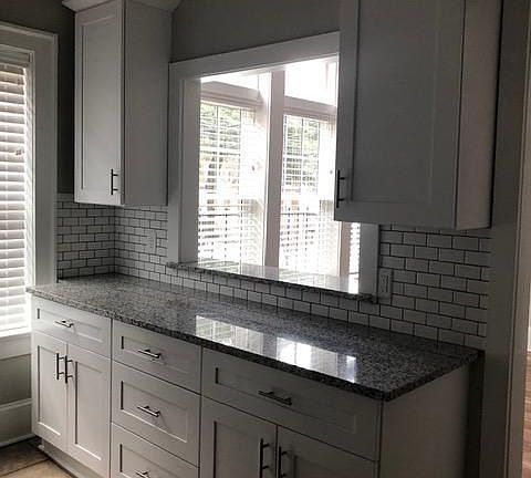 New cabinets on both sides of kitchen with lots of counter space.