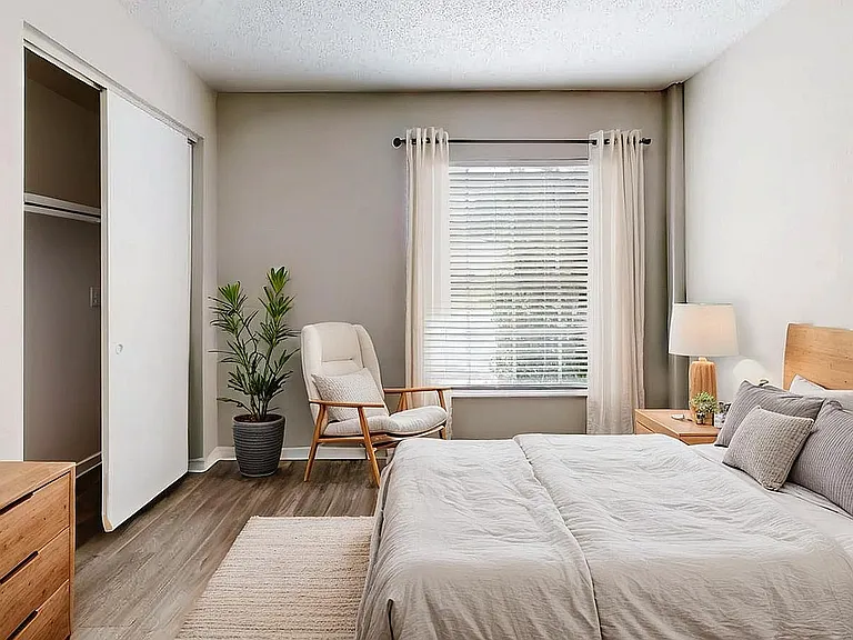 Bright and inviting bedroom with elegant decor, wooden accents, and a cozy reading nook by the window.