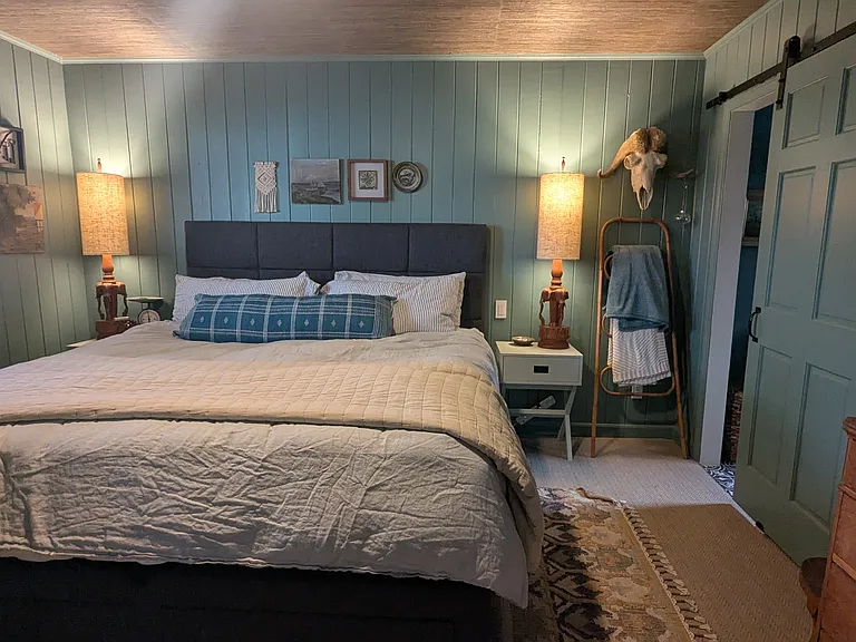 This single-story home has a spacious primary suite located on the opposite side of the house. The main bedroom has a king-size bed.