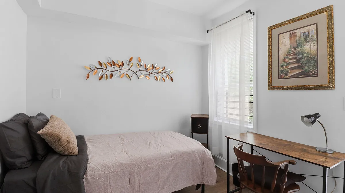 1st floor rear bedroom. With workspace, window, mini fridge, full length mirror and easy outdoor acces - W Lanvale St