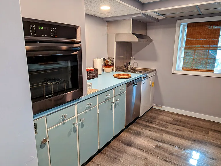 Full Kitchen with Ground Level Double Hung Window, Oven, Stove Top, Dishwasher, Microwave, Toaster Oven and Small Refrigerator. Full Size Refrigerator located in the Laundry Room.
