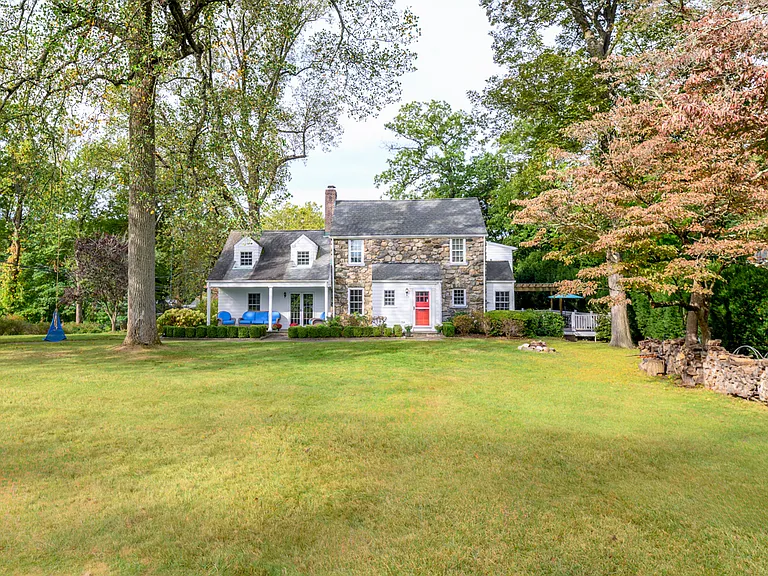 Spacious front lawn is highlighted by classic tree swings and apple trees