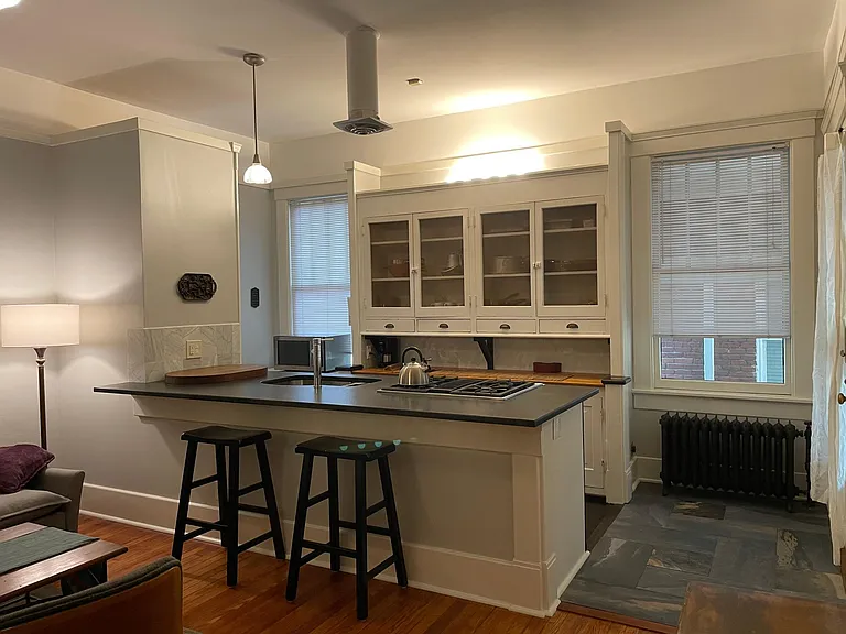 Black granite countertop w/ hutch style pantry cabinets.