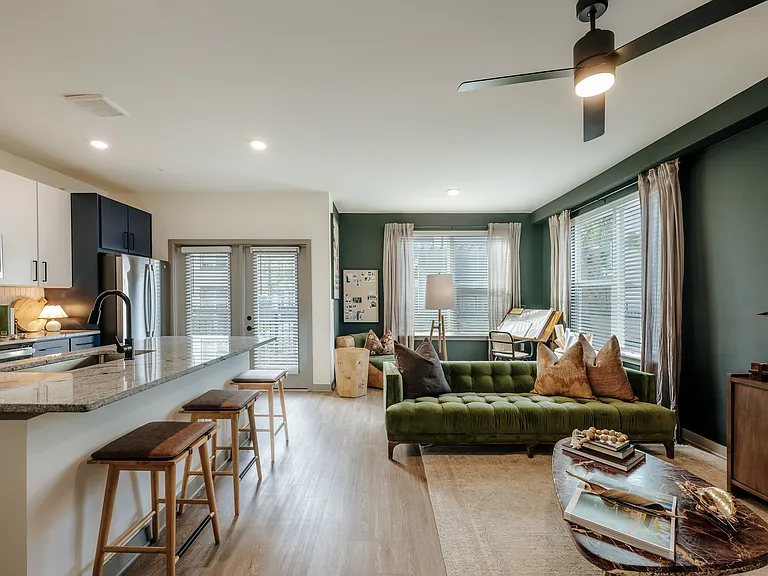 Modern apartment with open-concept kitchen, living and dining areas, granite countertops, and private patio or balcony access.