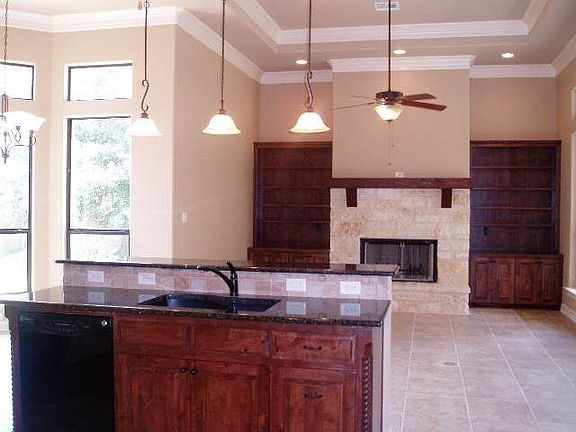 Cozy kitchen/living area with gas fireplace and detailed crown molding.