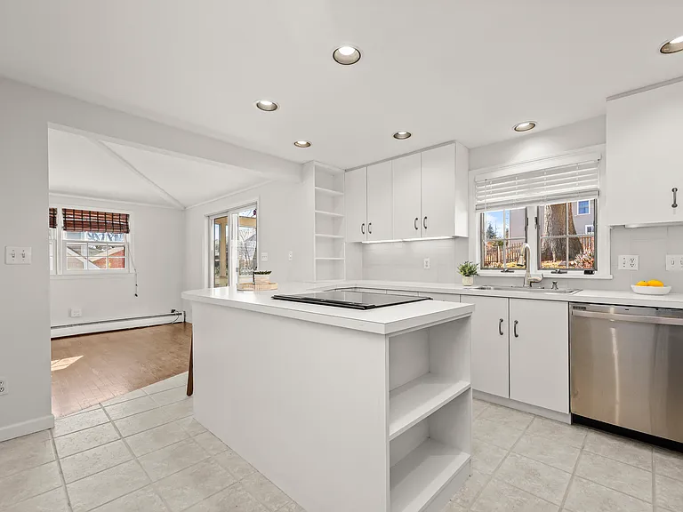 Bright white kitchen with views of backyard.