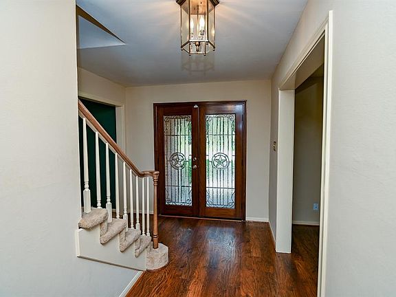 Formal entry with leaded glass door and wood flooring.