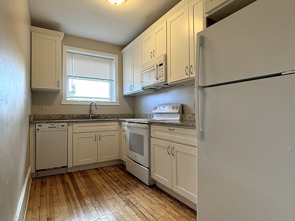 The kitchen is completely updated with white cabinets, granite countertops, and features a dishwasher, fridge, oven/stove, and microwave.
