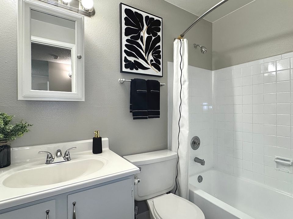 Sleek modern bathroom with a pristine bathtub, stylish vanity, and bright lighting.