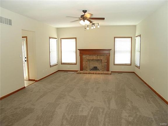 Here is the Family Room with a wood burning fireplace. The opening on the left leads to the wet bar and the kitchen as well as t