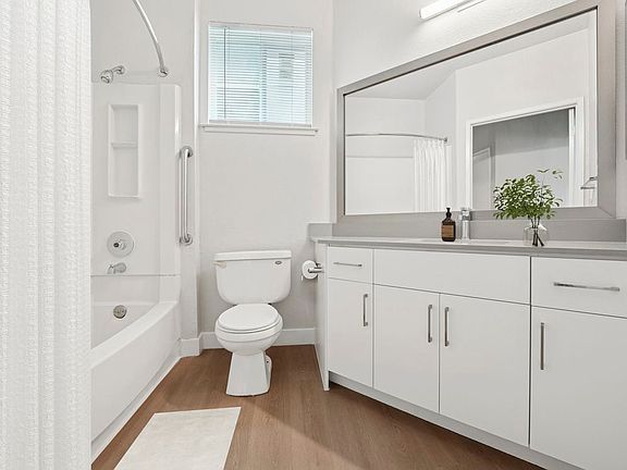 Renovated Package I bath with white cabinetry, grey quartz countertops, and hard surface flooring