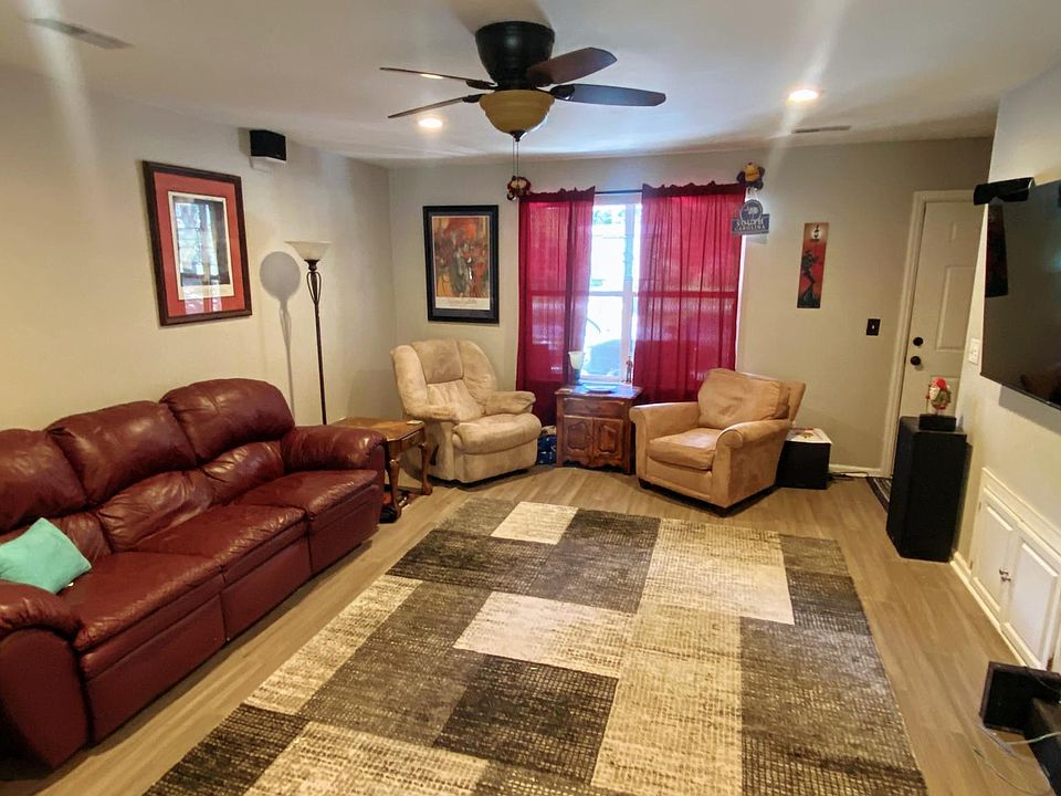 Living room with 65' Roku TV. open design with kitchen on other side and bathroom on side where TV is (out of frame)