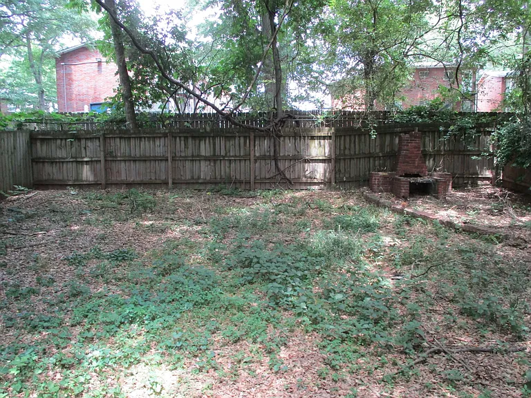 Large back yard, fully fenced in with a brick oven