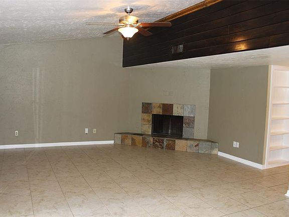 Spacious living room with woodburning fireplace.