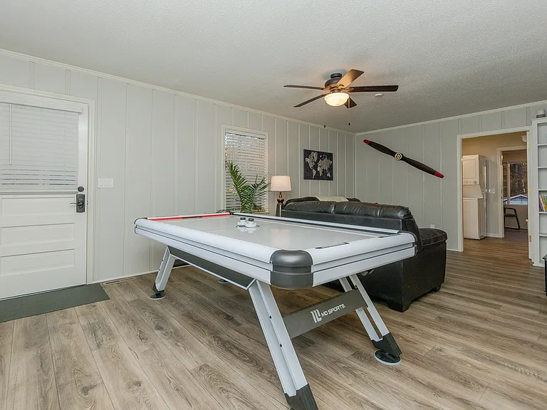Air hockey table, in gameroom looking into the full bath then sun room.