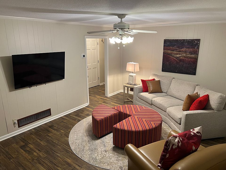 Family room/den, has ample seating w/ultra comfortable curved chenille sectional & round oversized nap sized ottoman or sit alone in the large leather chair. Lamp & end table w/ Wi-Fi smart tv set up 500+ channels. Gas fireplace & back deck access.