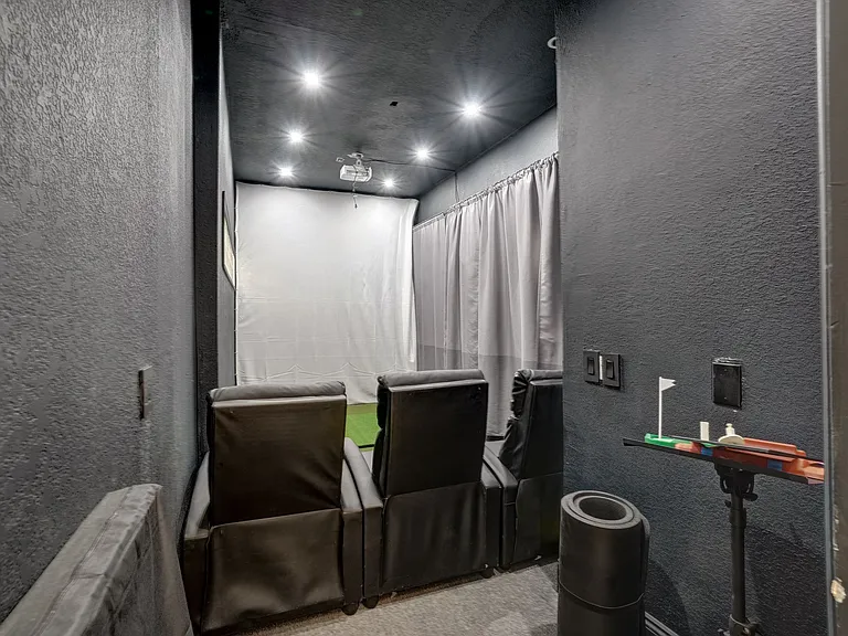 Ultimate Entertainment Hub: Experience a combined Golf Studio, Game & Movie room with cozy bean bag chairs for a perfect movie or game night.